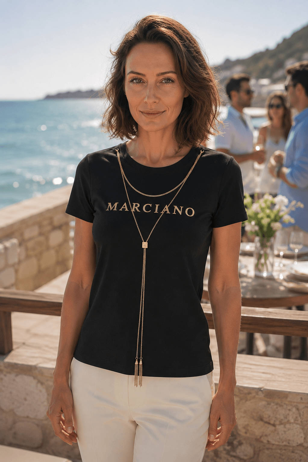 Marciano by Guess Logo T-Shirt with Gold Chain Necklace – Black worn by model at outdoor event, elegant women's fashion.